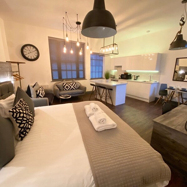 1 habitación, escritorio y tabla de planchar con plancha