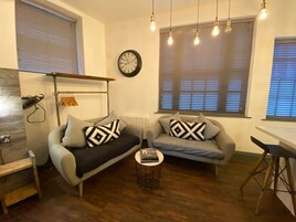 1 habitación, escritorio y tabla de planchar con plancha