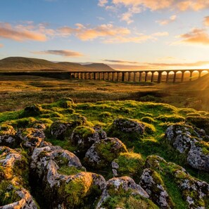 A stone viaduct over a grassy landscape with rolling hills in the background. - Town Hall Lofts Flat 1 Settle (Settle)