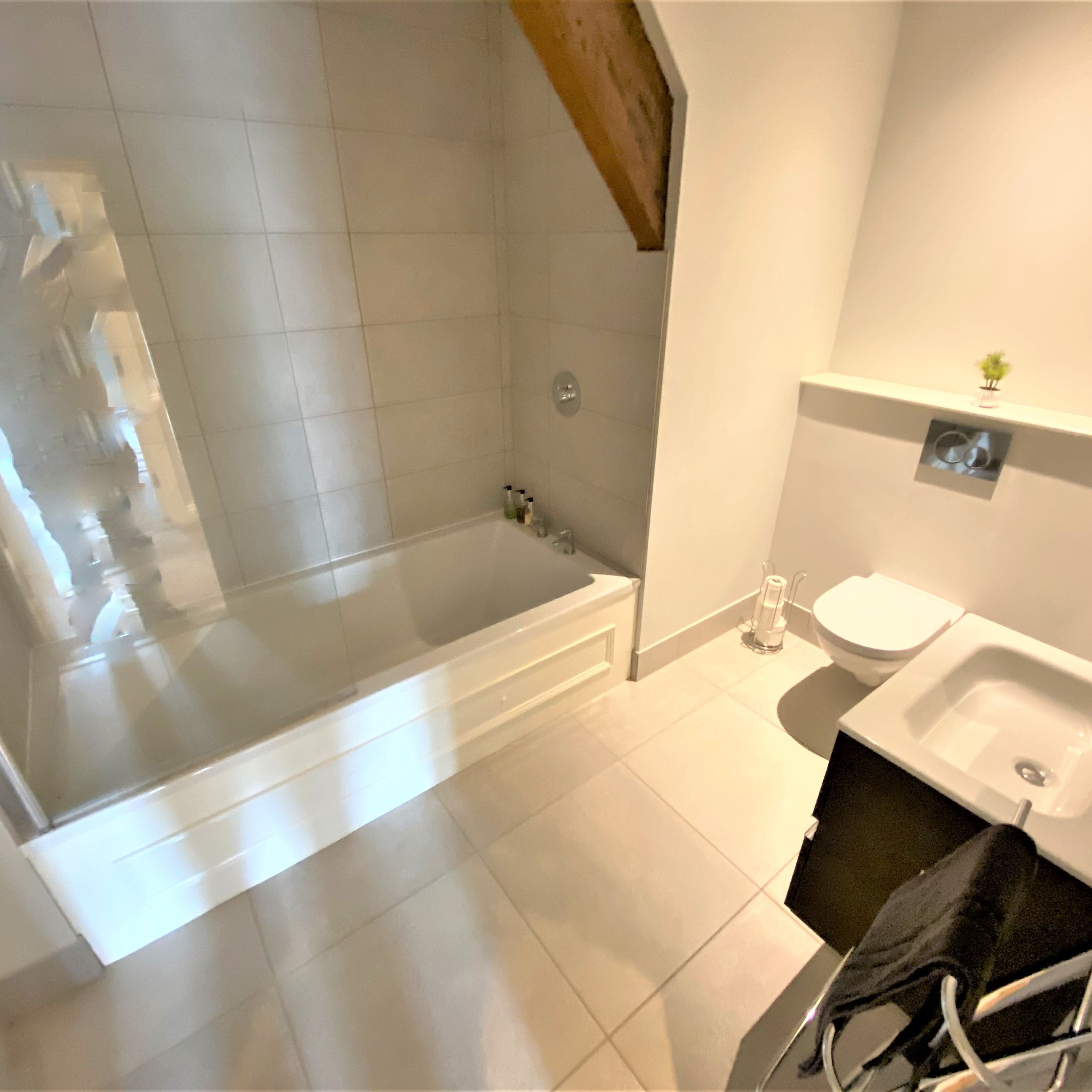 A bathroom with a bathtub, toilet, and sink.