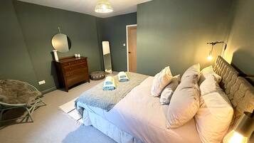 Ein Schlafzimmer mit einem Bett, einem Schminktisch, einem Stuhl und einem Spiegel.