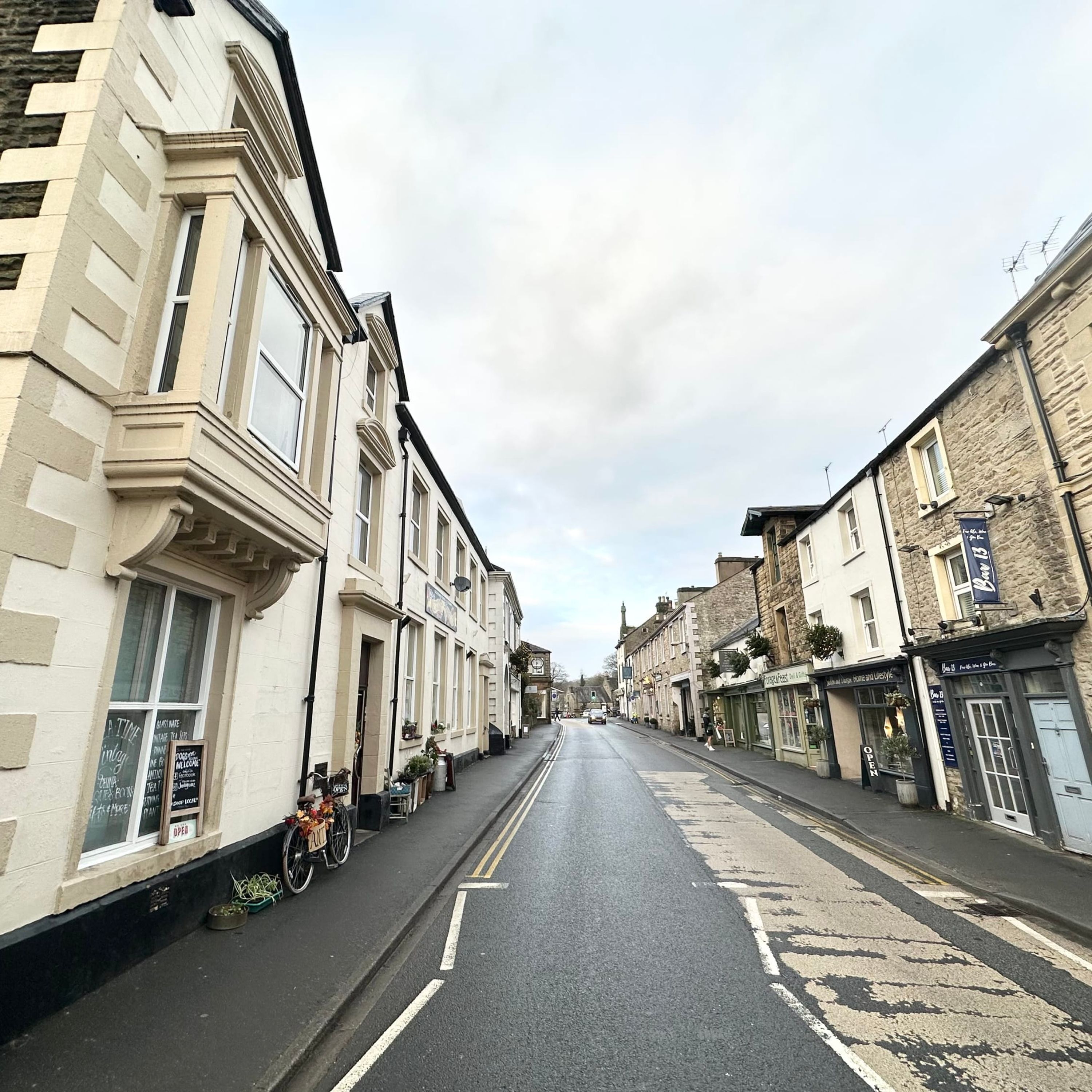 A street lined with traditional buildings, some with shops on the ground floor.