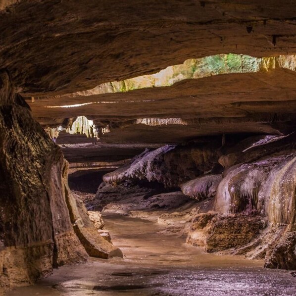 A cave with natural rock formations and a narrow passageway.