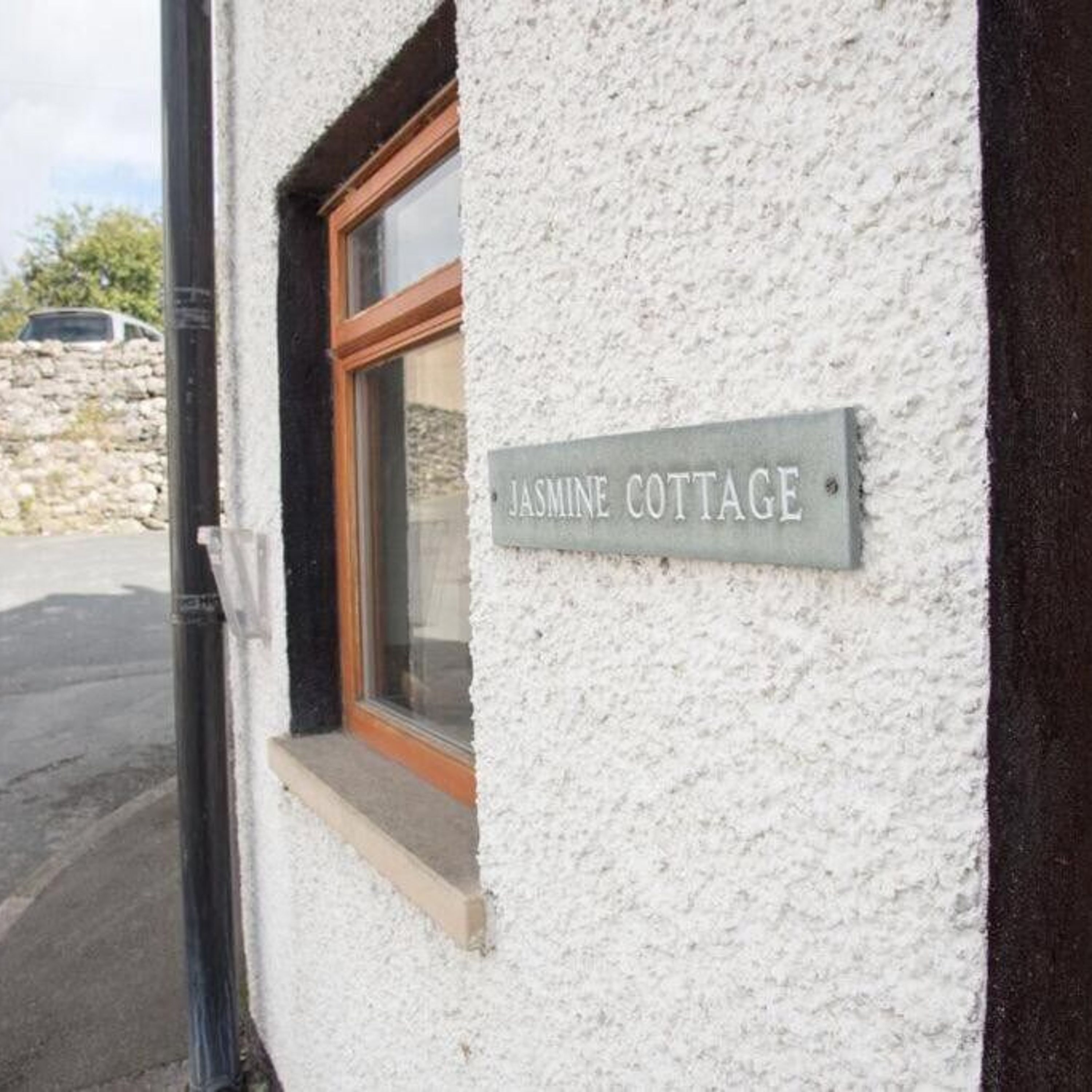 A sign on a building labeled "Jasmine Cottage."
