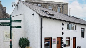 A white building with a signpost indicating directions to local attractions.