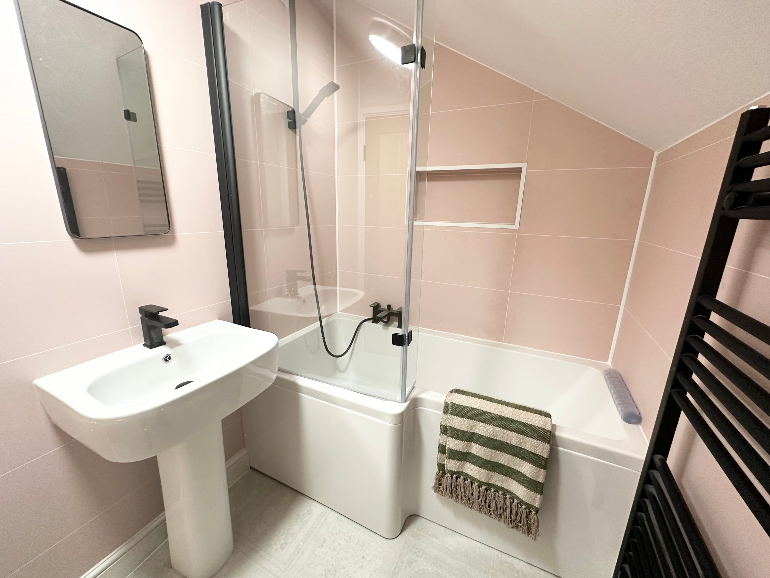 A bathroom with a white sink, a glass-enclosed shower, and a bathtub.