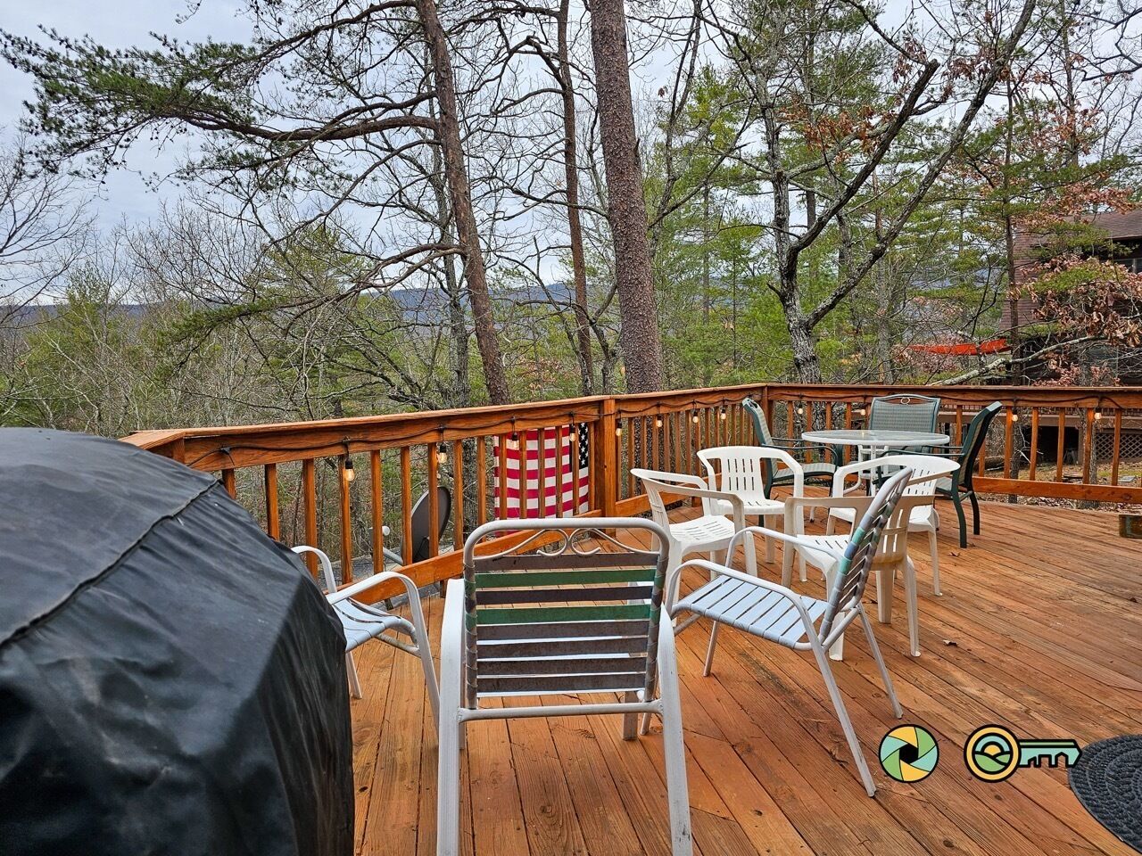 A wooden deck with outdoor furniture, including chairs and a table, and a barbecue grill.