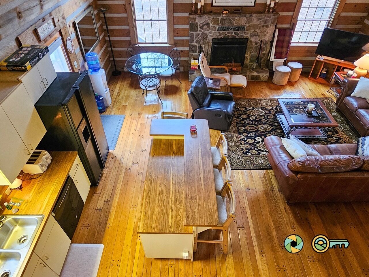 Un espacio habitable amplio con una mesa de comedor de madera, un sofá de cuero y una chimenea de piedra.