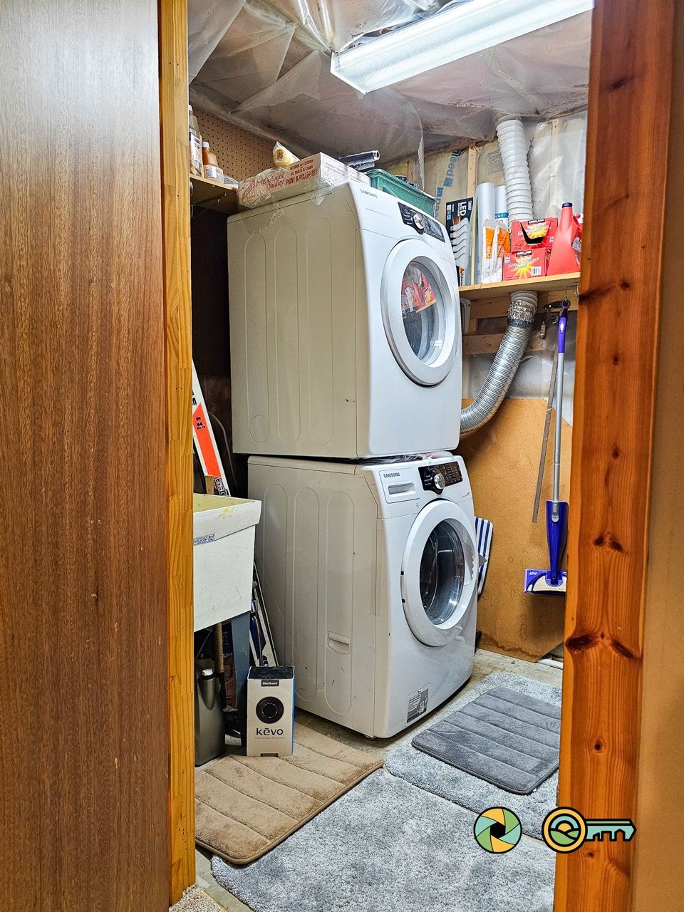 Een wasserette met gestapelde wasmachines, een Kevo apparaat en schoonmaakmiddelen.