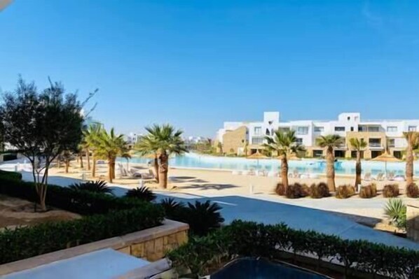 Un resort con piscina, palmeras y edificios modernos.
