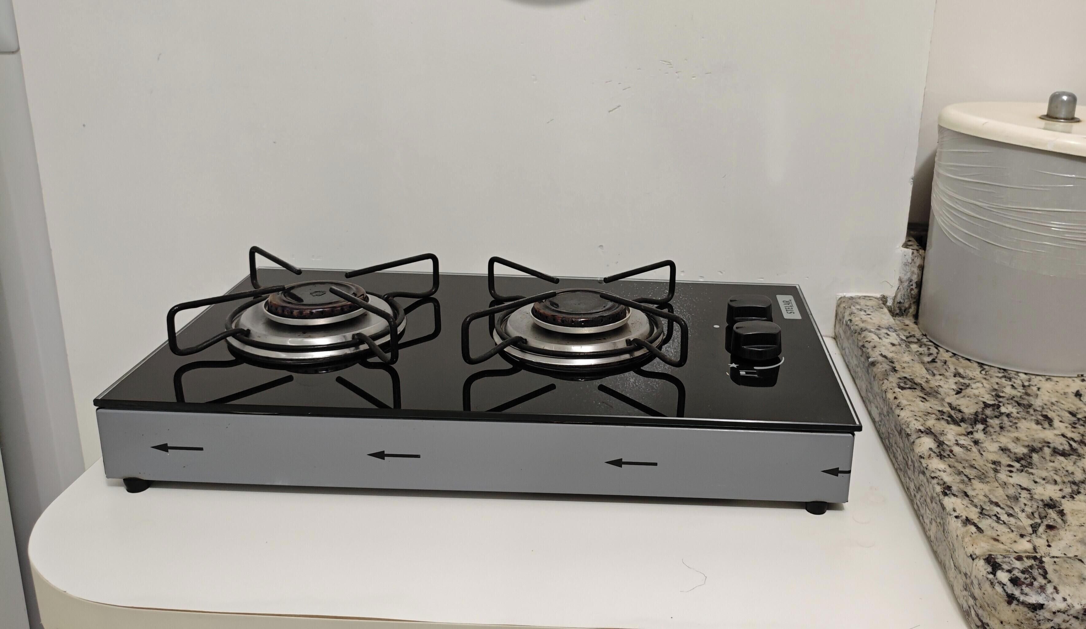 Une cuisine équipée d’une cuisinière à gaz, d’un évier et d’un plan de travail en granit.