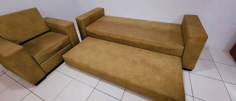 Un conjunto de sofás en una habitación con suelo de baldosas blancas.