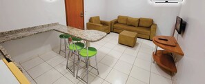 A compact living space with a kitchen area, a sofa, and a TV. Wi-Fi is available, and the room measures 42 inches. - Golden Dolphin GrandHotel - Piscinas 24h (Caldas Novas)