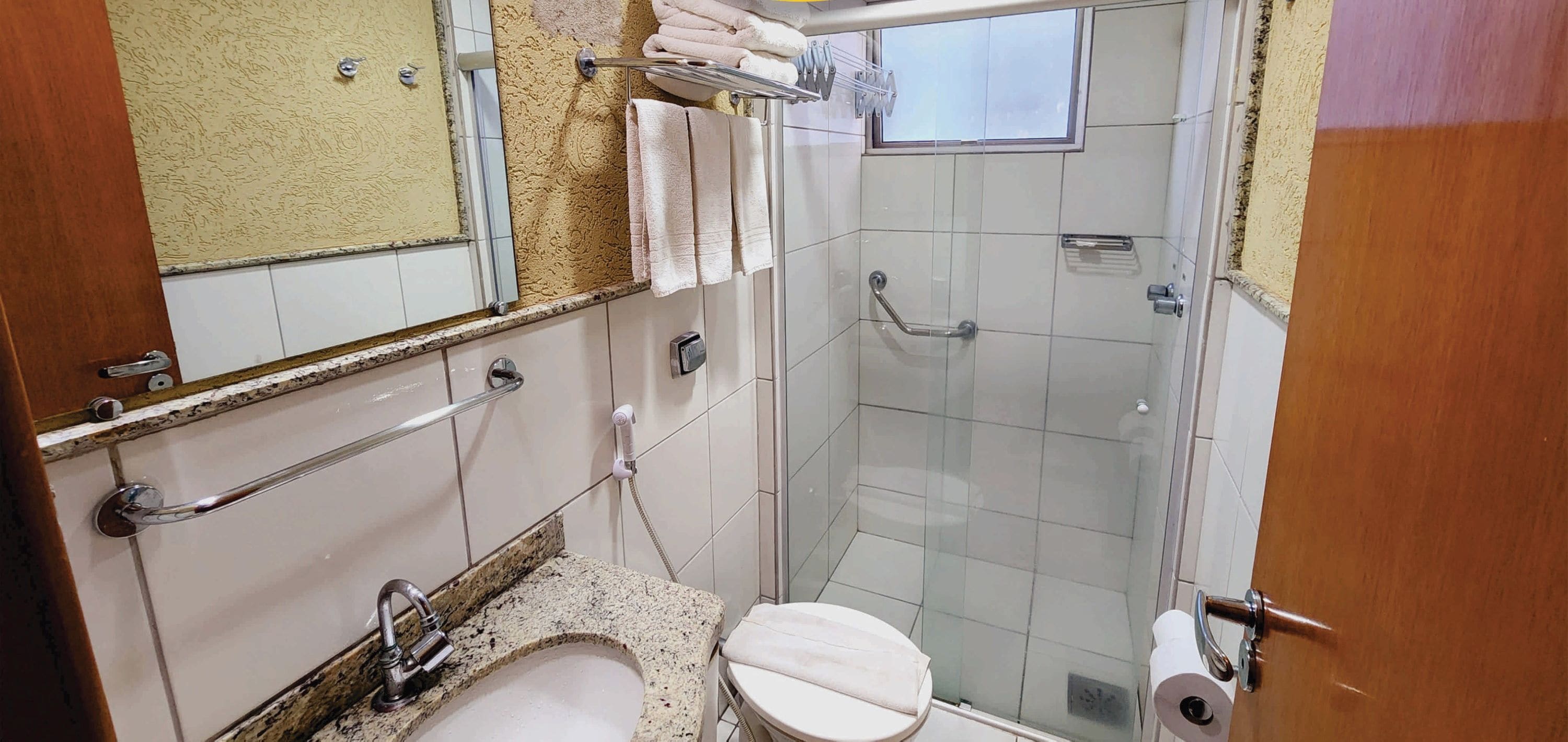 A small, compact bathroom with a shower, toilet, and sink.