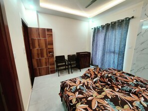 Relax in this stylish bedroom with a comfortable bed, wardrobe, and convenient storage.