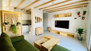 A modern living room with a green sofa, wooden coffee table, and a TV mounted on the wall. - Rustic 1 BR-Apt@ Swanlake - El Gouna (Second Hurghada)