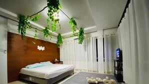 Ein Schlafzimmer mit einem Bett, einem grauen Teppich und einem an der Wand befestigten Fernseher.