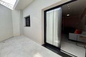 A modern interior with a sliding glass door leading to a living area with a sofa and a coffee table. - MY STUDIO  (Franca)