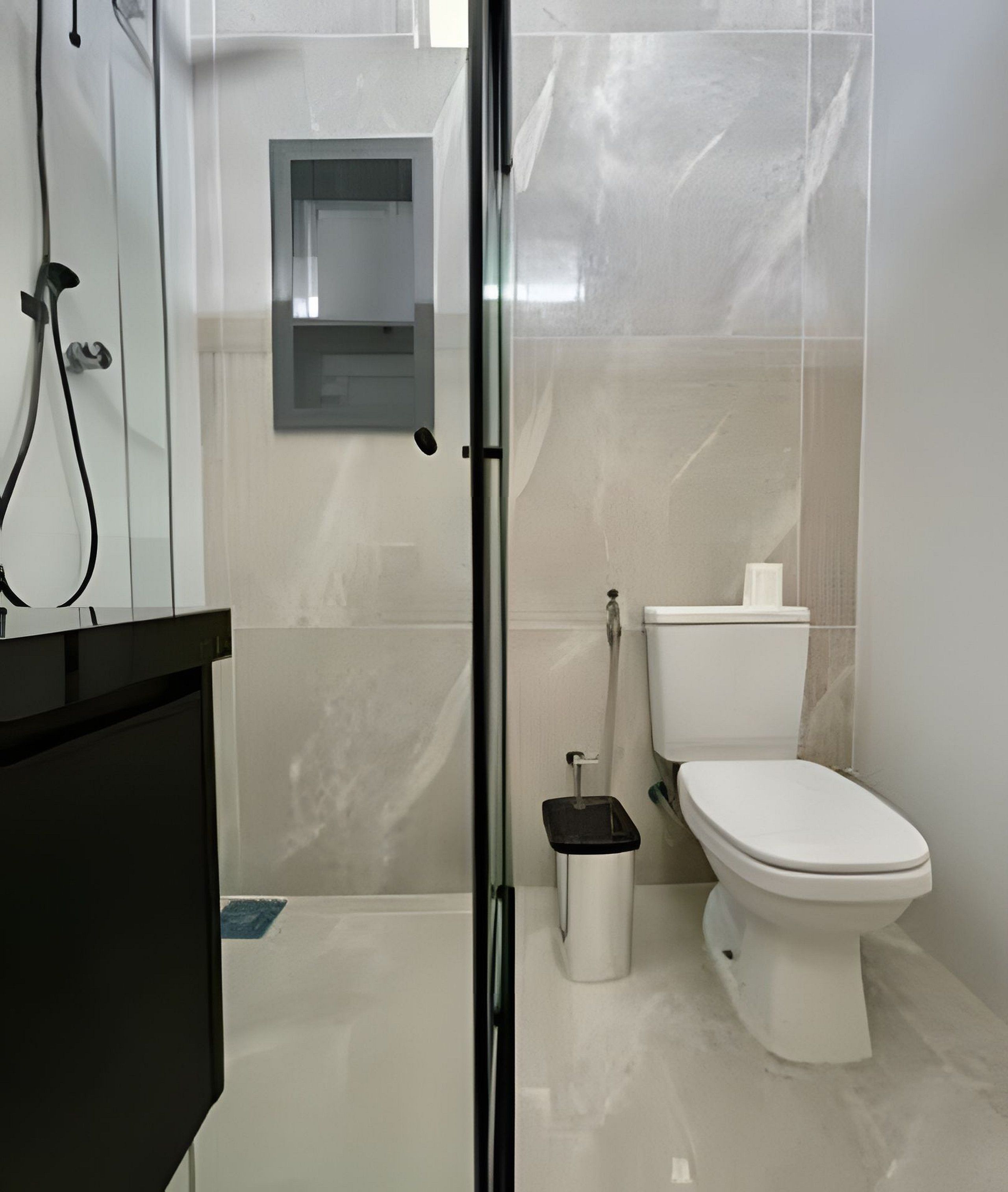 A modern bathroom with a toilet, bidet, and a glass shower enclosure.