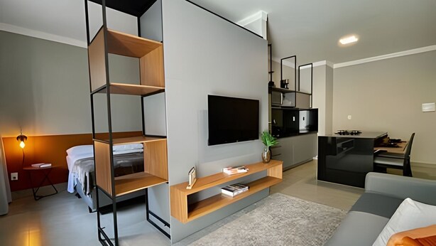Een moderne woonkamer met een bank, televisie en inbouwkasten.