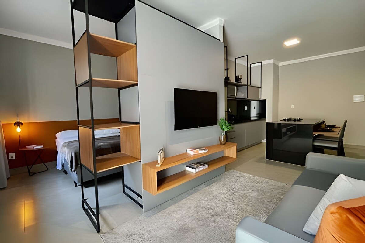 A modern living room with a sofa, TV, and built-in shelves.