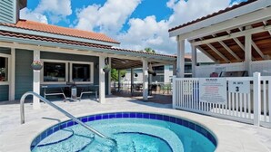 Une piscine entourée d’une clôture blanche, un espace de repos couvert et un panneau indiquant une profondeur de 3 pieds pour la zone spa.