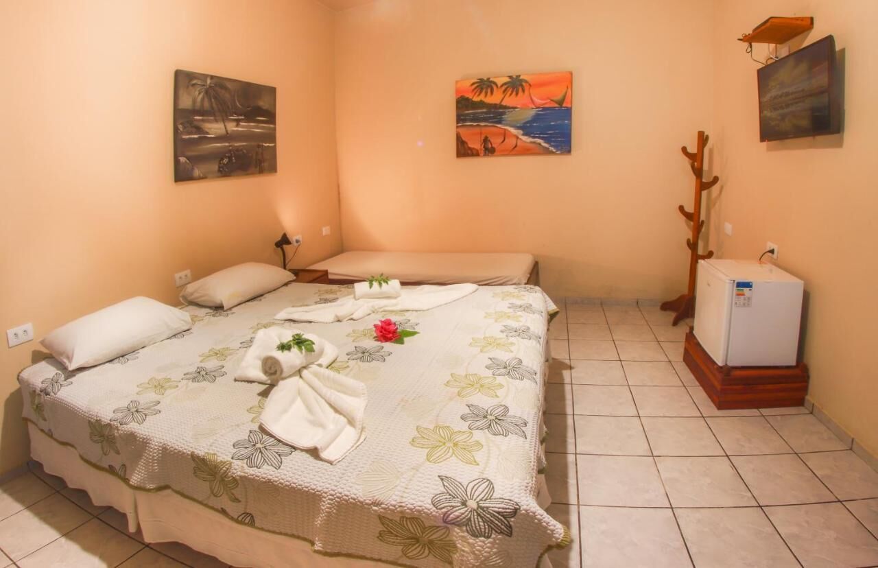 Una cama individual con ropa de cama floral, una mesita de noche pequeña y un radiador de pared.