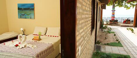 Habitación de hotel con cama, un cuadro y vistas a la playa y una torre.