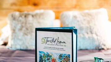 Un menu incorniciato del ristorante e boutique hotel Twisted Lemon, con un cesto di limoni e una candela su un tavolo.
