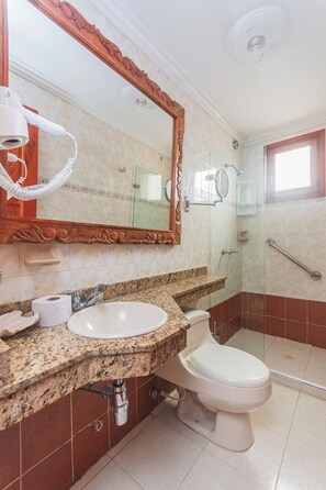 A bathroom with a sink, toilet, mirror, and shower. - HOTEL BALUARTE BOUTIQUE CARTAGENA  (Cartagena)