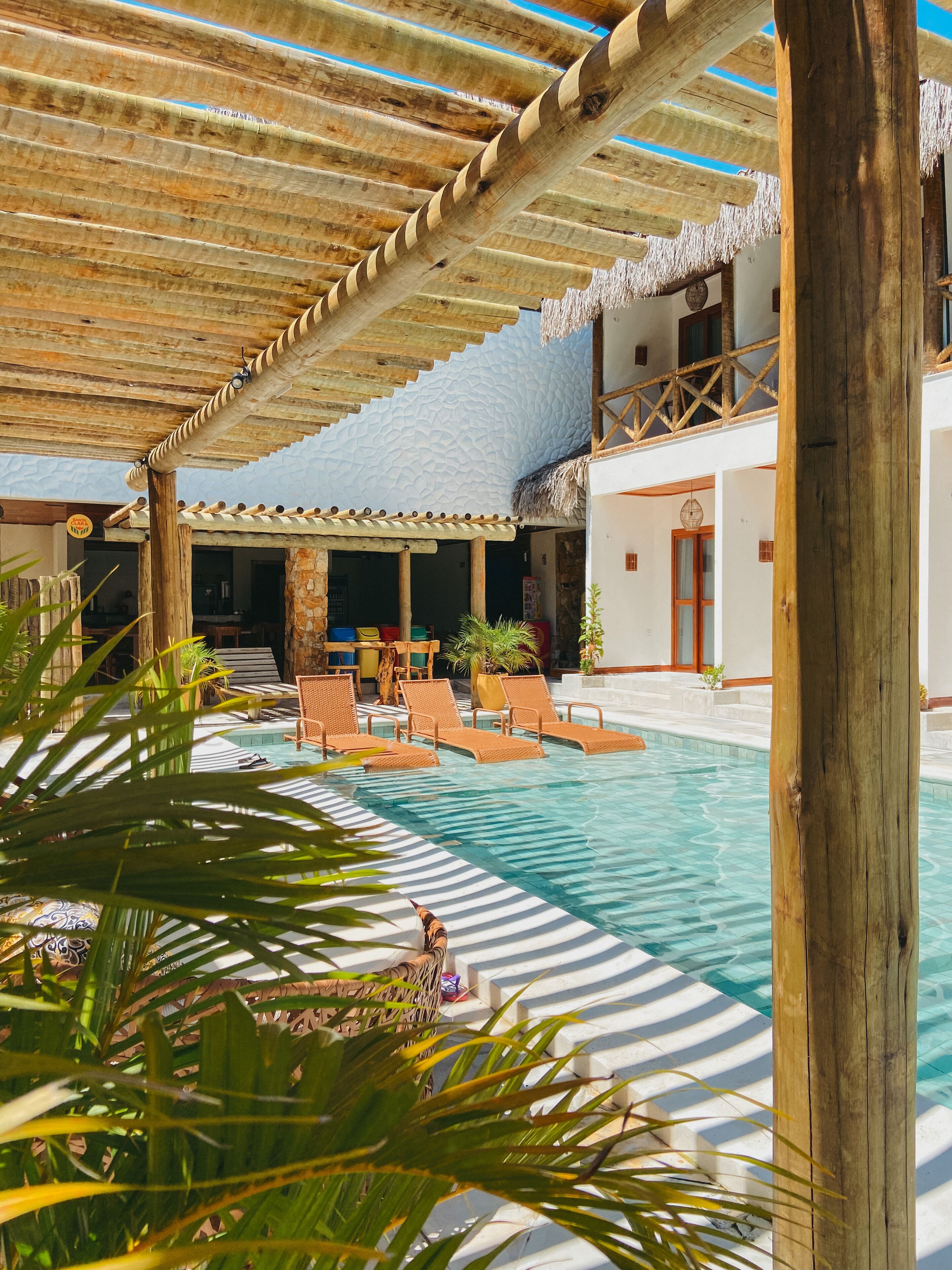 Un espace piscine avec des chaises longues et un coin salon abrité.