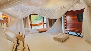 A room with a bed under a canopy, a bench, and a view of the outdoors. - Pousada Velho Chico (Amontada)