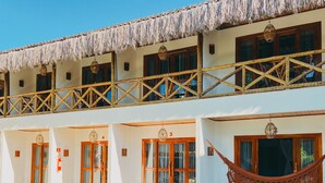 A resort with a pool, wooden deck chairs, and a thatched roof balcony. - Pousada Velho Chico (Amontada)