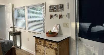 Step into this cozy 2-bedroom cabin nestled in the tranquil woods. The main living area offers comfy seating, including a pull-out futon for additional sleeping space. An efficiency kitchen awaits your culinary adventures, equipped with essentials fo