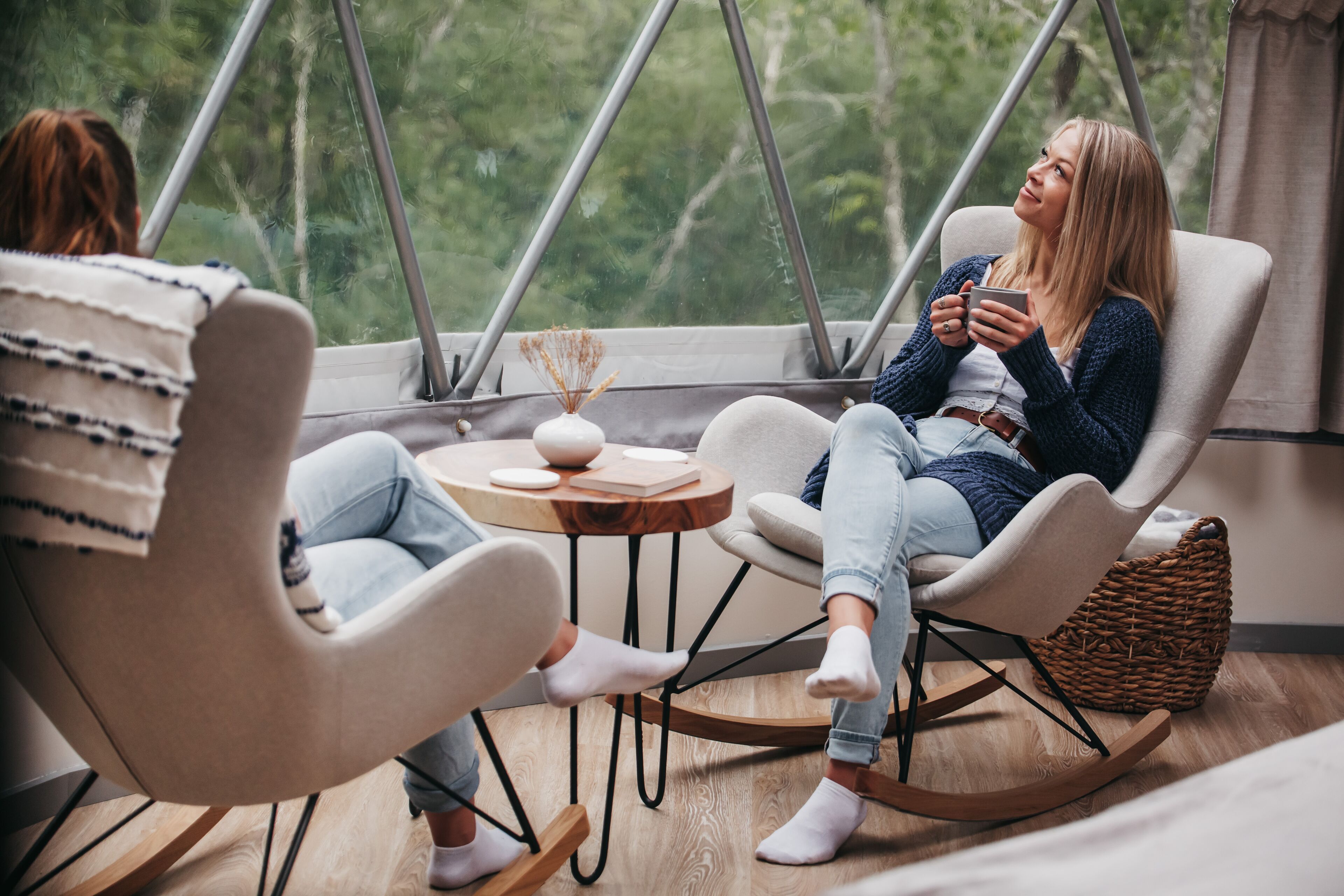 A cozy room with a large window, a round wooden table, and two chairs.