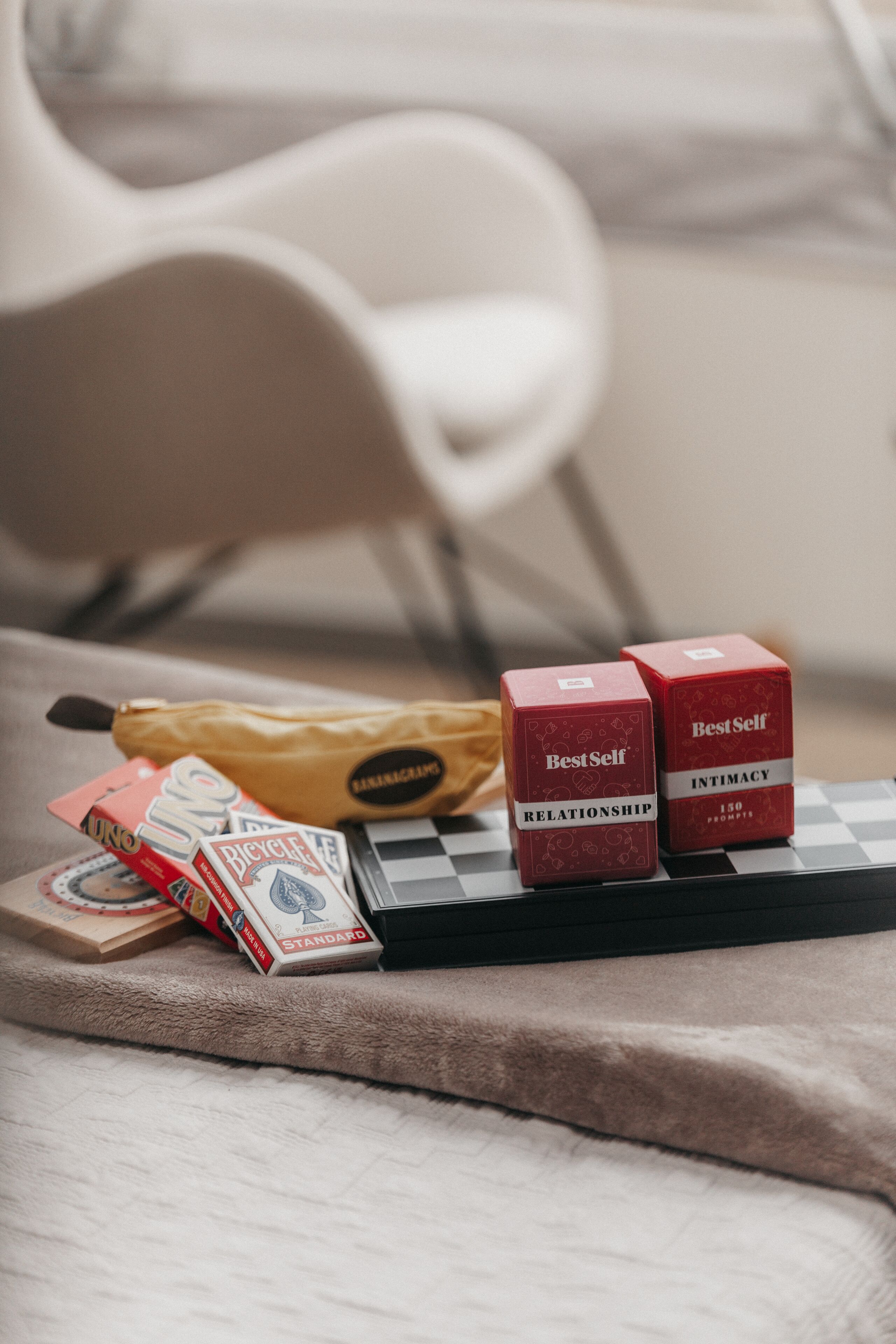 A checkered tray with two red boxes labeled "Best Self" and "Intimacy," a banana, and some cards on a textured surface.