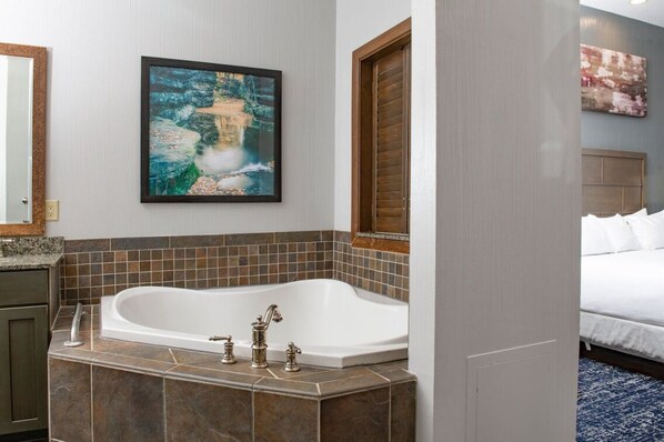 Un baño moderno con una bañera independiente, un espejo grande y un cuadro enmarcado en la pared.