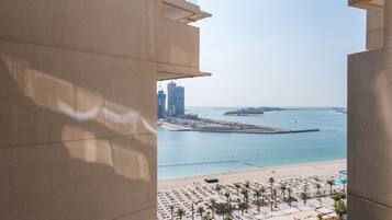 A high-rise hotel with a view of a beach and marina.