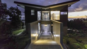 Een modern huis met een centrale trap die leidt naar een balkon.