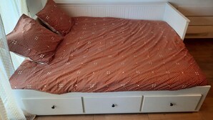 A small, white, single-bed room with a patterned bedspread and matching pillows. - Studio de 22m 2 (Etrembières)