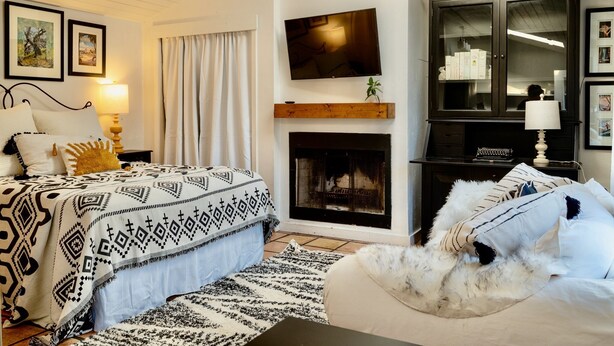 A bedroom with a bed, a fireplace, a television, and a cabinet. - Cozy Historical Cottage In Petaluma (Petaluma)