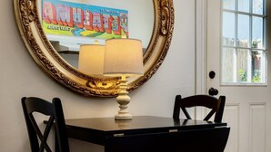 A dining area with a table, chairs, a lamp, and a large ornate mirror. - Cozy Historical Cottage In Petaluma (Petaluma)