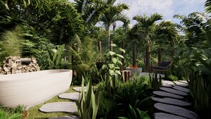 Un jardin tropical avec un sentier en pierre, un grand bac à plantes et un espace détente comprenant une chaise et une table.