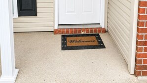 A front door with a mailbox, a doorbell, and a welcome mat. - Relax in our beautiful New Orleans themed townhome

 (Ponchatoula)
