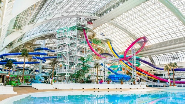 An indoor water park with multiple water slides and a central pool area. - NEW - Euro-Style Suite - Whyte Ave/Clean/A/C/NFLX/Sleeps6
 (Edmonton)