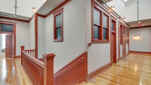 A spacious hallway with wooden floors and red-framed windows. - Downtown Hot Springs Condo Near Bathhouse Row! (Hot Springs)