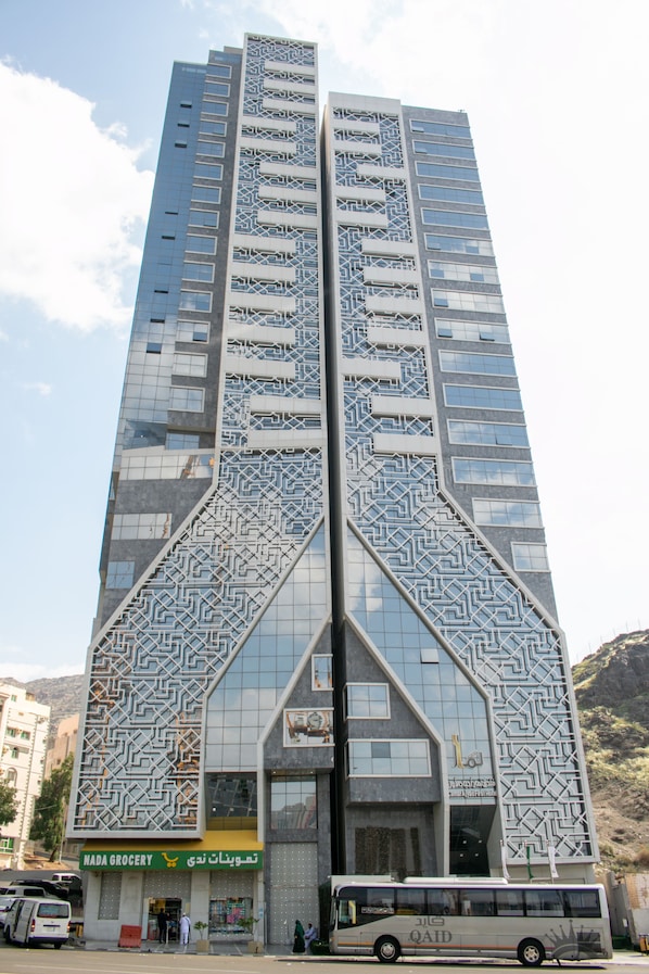 Un edificio alto con una fachada geométrica distintiva y una tienda visible que dice "NADA GROCERY".