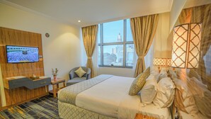A hotel room with a bed, a TV mounted on the wall, a desk with a phone, and a window with curtains. - Lamar Ajyad First Hotel Tower B (Makkah)