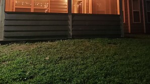 Een gebouw met een overdekte veranda, lichtjes en een plafondventilator.