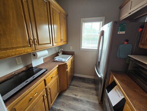 Een microgolfoven, kookgerei, borden en bestek, kruiden, keukenpapier